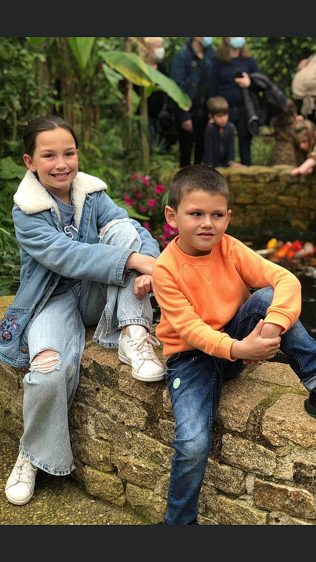 Ilyana a rejoint le concours — aidez-le/la à gagner de superbes lots ! adaptation, child, event, footwear, gesture, grass, happy, jeans, joy, leaf, leg, leisure, people_in_nature, person, plant, shoe, sitting, smile, sneakers, toddler