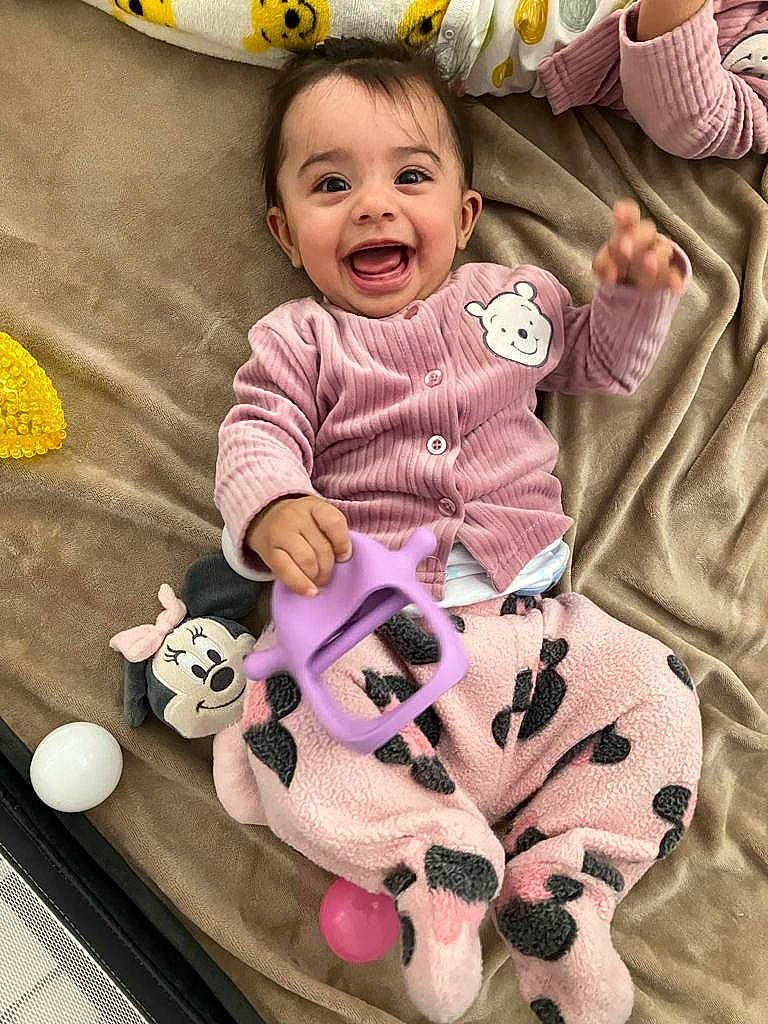 Maya is registered to the contest to win money with this photo: baby, baby_toddler_clothing, beauty, cheek, eye, fun, happy, head, joy, mammal, person, pink, product, purple, skin, sleeve, smile, textile, toddler, toy