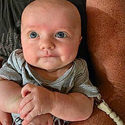 Wren joined the competition — help win amazing prizes! adult, baby, background, casual, child, closeup, clothing, curious, cute, expression, face, grey_shirt, hands, holding, indoor, infant, person, portrait, skin, texture