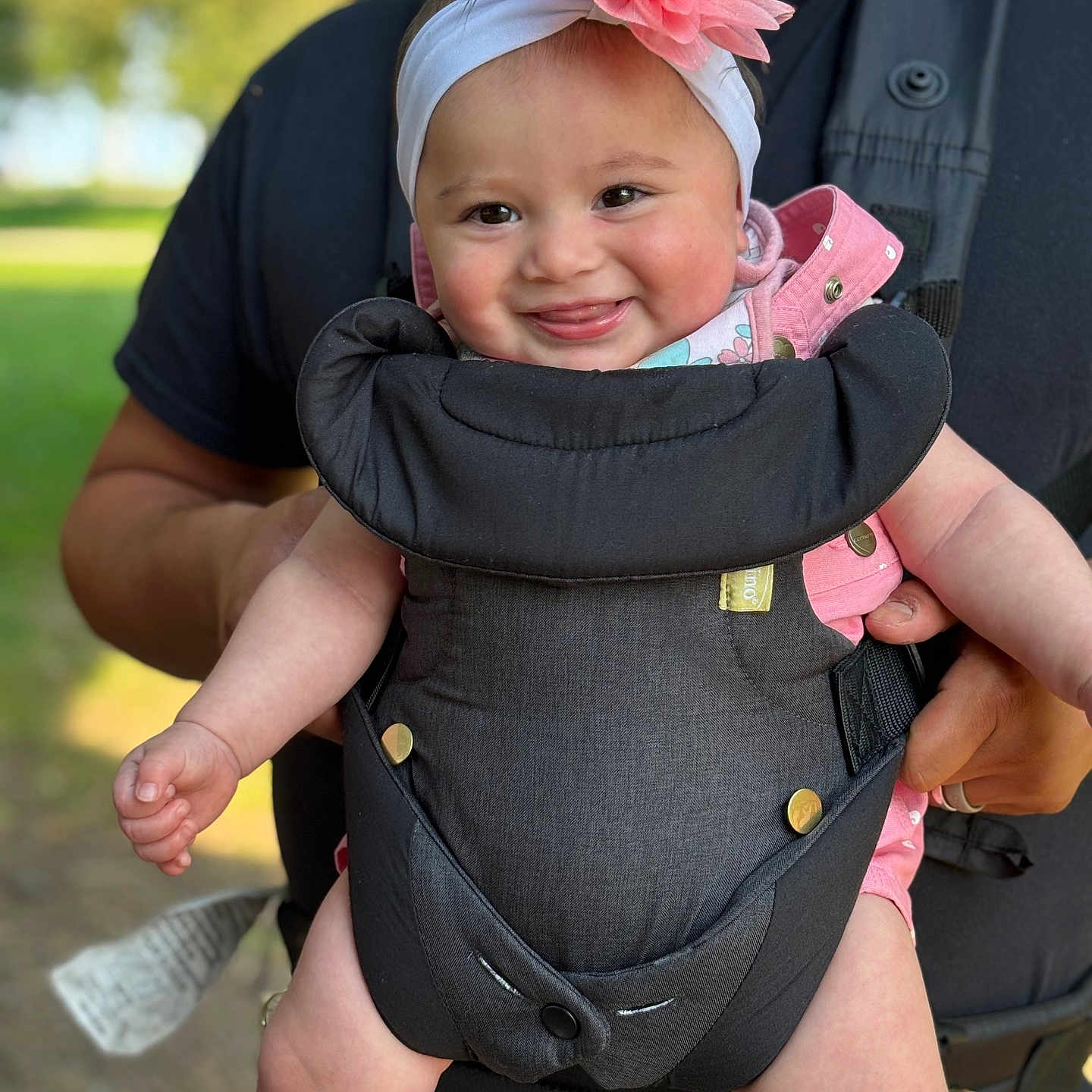 Ezme is registered to the contest to win money with this photo: adult, baby, baby_carrier, child, clothing, cute, flower, greenery, hands, happy, head, headband, infant, nature, outdoor, person, portrait, skin, smile, sunlight