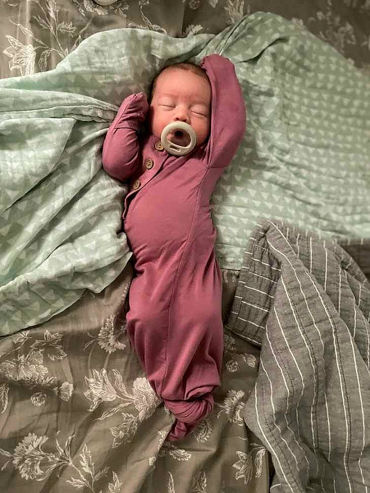 Henley is registered to the contest to win money with this photo: baby, baby_toddler_clothing, beauty, bed, bedding, bedtime, child, comfort, face, grass, head, linens, magenta, pattern, person, room, skin, sleep, sleeve, textile