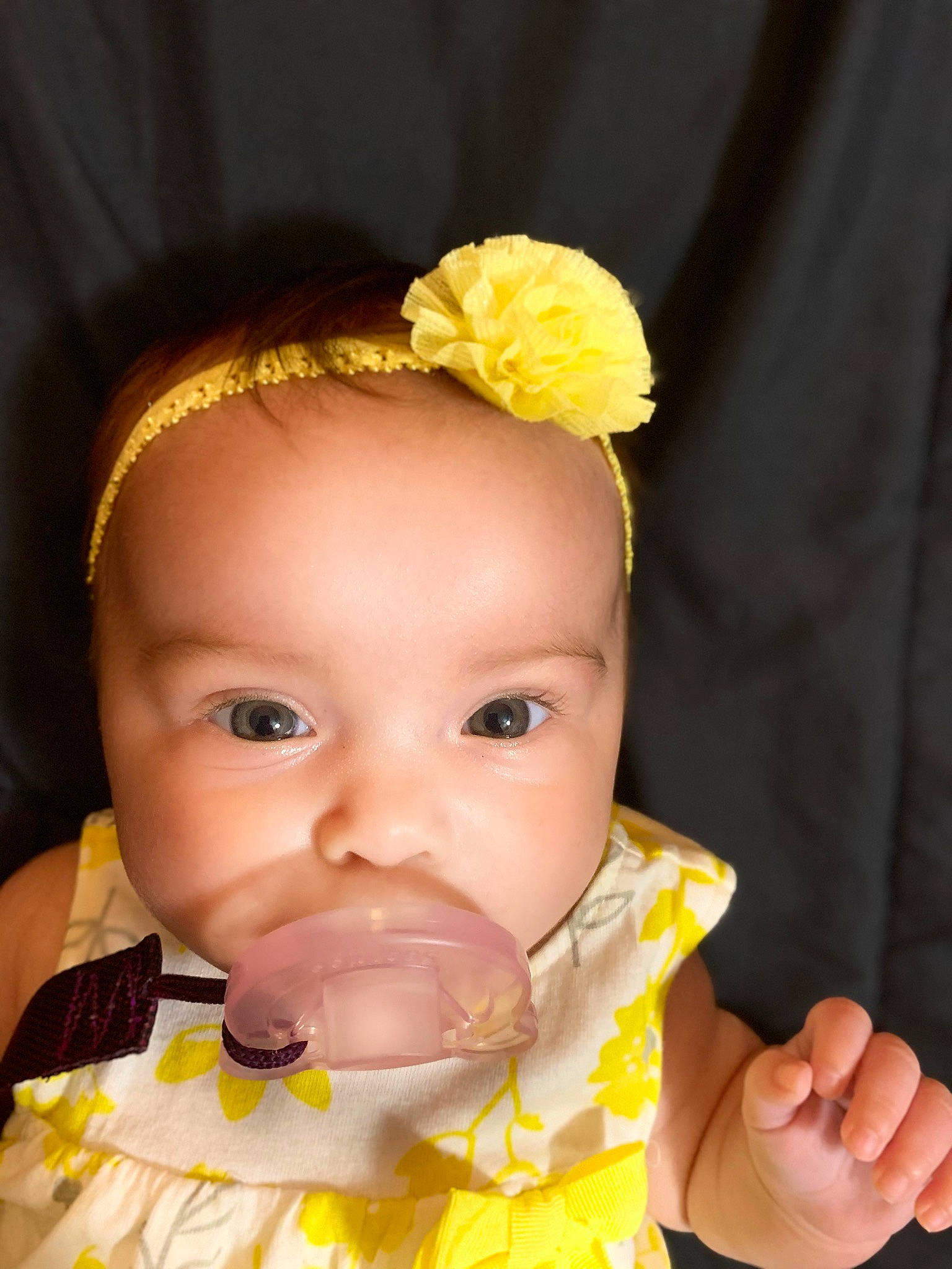 Elodie is registered to the contest to win money with this photo: baby, baby_toddler_clothing, cheek, child, chin, close_up, ear, eyebrow, eyelash, finger, flower, happy, headband, iris, lip, mouth, nose, person, skin, toddler