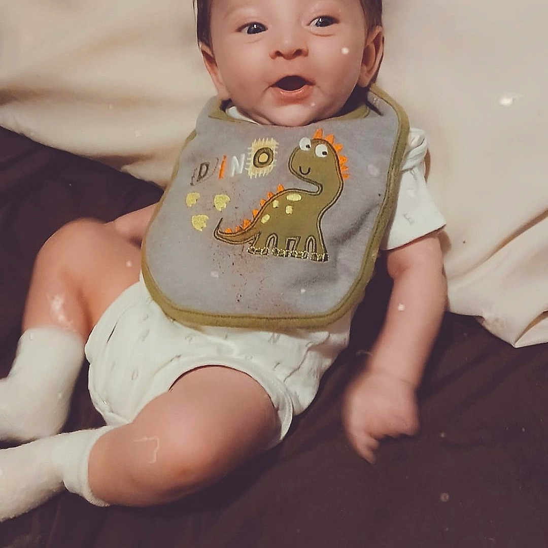 Easton joined the competition — help win amazing prizes! accessories, baby, bed, clothing, couch, cushion, diaper, dress, face, furniture, happy, head, homedecor, jewelry, necklace, person, photography, portrait, sitting, smile