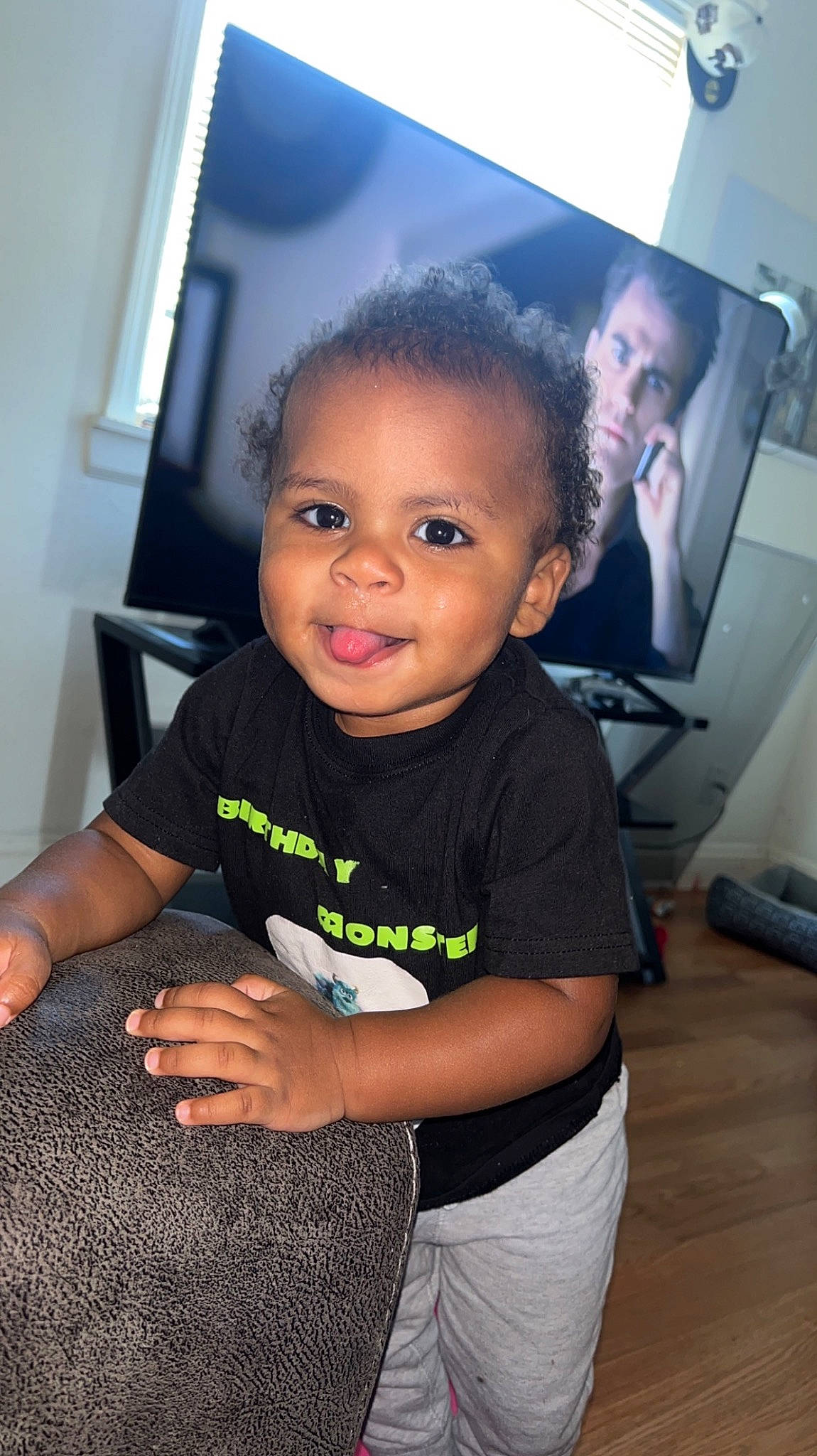 Kaison is registered to the contest to win money with this photo: baby_toddler_clothing, black_hair, cheek, child, elbow, face, flash_photography, flooring, fun, happy, head, person, room, sitting, skin, sleeve, smile, standing, t_shirt, thumb