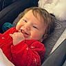 Elyanna is registered to the contest to win money with this photo: baby, blue_eyes, brown_hair, car_seat, chewing, child, close_up, earring, fluffy_toy, hand, happy, indoor, infant, onesie, pacifier, portrait, red_clothing, sitting, smiling, vehicle