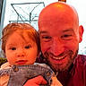 Elyanna is registered to the contest to win money with this photo: adult, baby, bald, beard, child, clothing, eyes, face, family, father, holding, indoor, infant, outdoor_view, overalls, parent, portrait, selfie, smiling, window