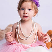 Elyanna is registered to the contest to win money with this photo: child, toddler, portrait, birthday, party_hat, pink_tutu, pearl_necklace, jewelry, blue_eyes, blonde_hair, sitting, indoors, studio_lighting, plush_toy, pink, purple, fashion, celebration, cute, photography