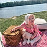 baby, blanket, bonnet, child, doll, gingham, grass, infant, lake, lakeside, outdoor, picnic, portrait, sitting, smiling, stuffed_bunny, sunlight, trees, water, wicker_basket