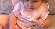 Elyanna is registered to the contest to win money with this photo: child, toddler, baby, portrait, sitting, couch, indoor, pink_clothing, hair_clip, brown_hair, face, eyes, serious_expression, person, furniture, soft_lighting, home, casual, photography, close_up