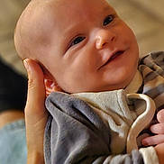 Milo participe au concours pour gagner de l'argent avec cette photo : baby, smiling, face, hand, person, clothing, infant, cute, portrait, closeup, warm, cozy, soft_focus, indoor, happy, newborn, baby_garment, holding, parent, love