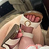 Paislee is registered to the contest to win money with this photo: baby, feet, sandals, white_sandals, baby_feet, baby_clothing, white_clothing, pink_trim, infant, child, leg, adult_leg, living_room, couch, furniture, blurred_background, footwear, close_up, indoors, cute