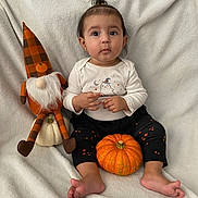 Angelica is registered to the contest to win money with this photo: autumn, baby, barefoot, black_pants, child, cute, decor, fall, gnome, holiday, indoors, long_sleeve_shirt, orange_stars, plaid, portrait, pumpkin, sitting, stuffed_toy, topknot_hair, white_blanket