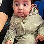 Angelica joined the competition — help win amazing prizes! baby, infant, child, onesie, clothing, sitting, face, eyes, hands, foot, person, indoor, cozy, portrait, cute, soft_texture, pattern, lap, expression, curious