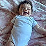 Kennedy joined the competition — help win amazing prizes! baby, infant, smile, white_onesie, pink_blanket, floral_pattern, happy, lying_down, child, cute, soft_texture, skin, hair, portrait, one_person, indoors, young_child, baby_clothing, relaxing, playful