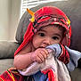 Winston is registered to the contest to win money with this photo: baby, child, towel, blanket, couch, indoor, face, hand, curious, superhero, colorful, window_blinds, soft_light, skin, cute, portrait, comfort, seated, young, cozy