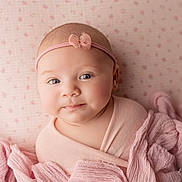 Josie joined the competition — help win amazing prizes! baby, infant, pink, headband, bow, wrapped, blanket, soft_fabric, portrait, blue_eyes, face, cute, child, newborn, lying_down, pastel, patterned_background, closeup, skin, peaceful