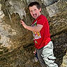 Robert joined the competition — help win amazing prizes! child, boy, smiling, tongue_out, climbing, rock_climbing, rock_wall, outdoor, adventure, red_shirt, gray_pants, cave, rocks, stone, nature, playful, portrait, summer, happy, photography