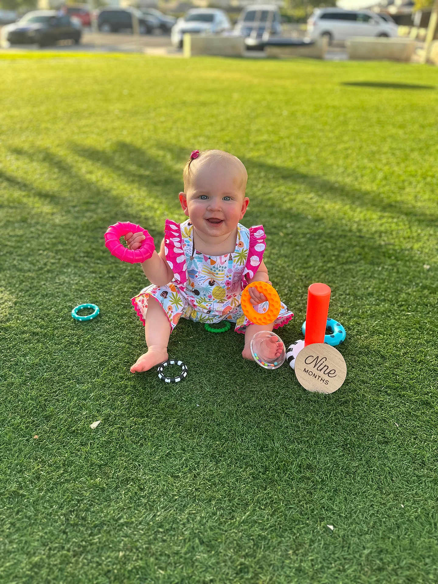 Savannah joined the competition — help win amazing prizes! baby, child, grass, toy, colorful, smiling, outdoor, nine_months, milestone, happy, sitting, playful, sunny, daylight, cute, clothing, rings, park, infant, nature