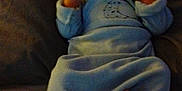 Zayden is registered to the contest to win money with this photo: baby, blanket, blue_clothing, child, comfort, couch, cute, face, foot, hand, indoor, infant, onesie, portrait, relaxed, resting, sleepwear, smiling, soft_lighting, young_child