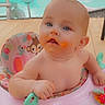 activity_seat, baby, bald, blue_eyes, child, curious, deck, face, food, infant, messy_face, orange_food, outdoor, playtime, pool, portrait, safe, sitting, sunlight, toys