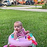 baby, cars, child, curious, daylight, face, grass, hand, house, lawn, outdoor, pink_walker, playtime, portrait, residential_area, road_sign, sitting, toddler, toy, walker