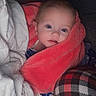 baby, bed, bedding, blanket, child, close_up, coral_blanket, cozy, cute, eyes, face, home, indoors, infant, lying_down, plaid_fabric, portrait, sitting, textile, wide_eyed