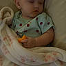 baby, bed, bedroom, blanket, cozy, cuddled, eyes_closed, face, indoors, infant, ladybug_pattern, nap, orange_food, pajamas, portrait, resting, sitting, sleeping, snack, soft_blanket