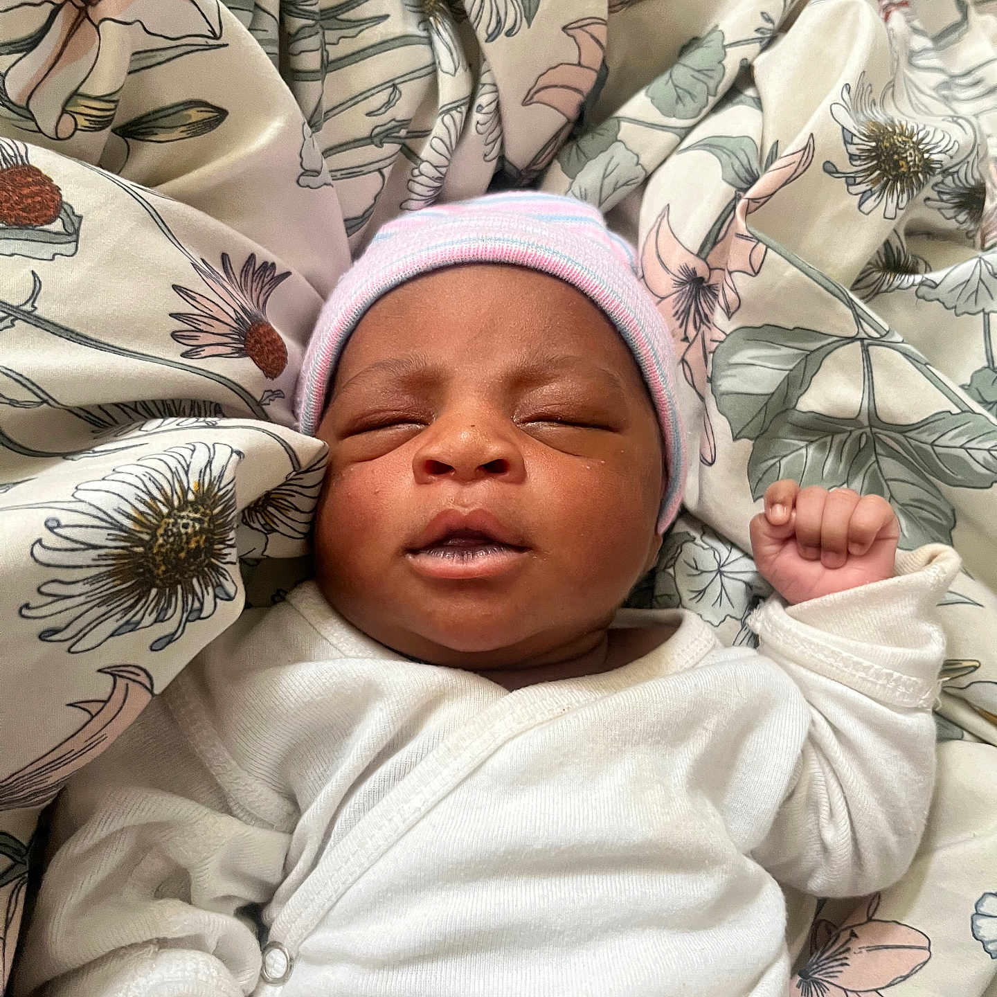 Erriyah joined the competition — help win amazing prizes! baby, newborn, infant, sleeping, hat, white_clothing, blanket, floral_pattern, peaceful, cute, fist, indoors, child, portrait, soft, cozy, resting, person, closeup, headwear