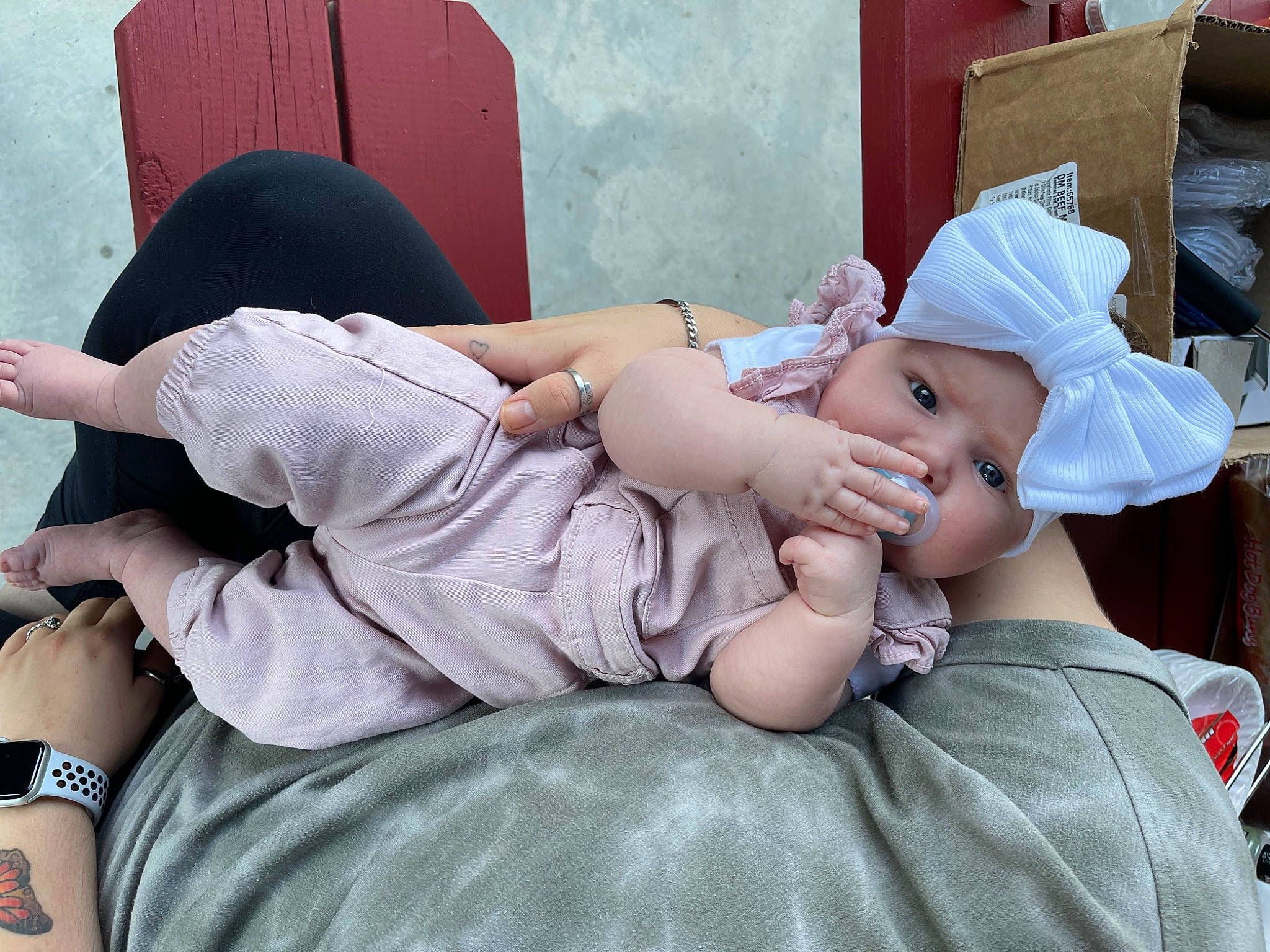 Journey is registered to the contest to win money with this photo: baby, baby_toddler_clothing, comfort, elbow, eyewear, grass, happy, hat, headgear, headwear, human_leg, joint, knee, leg, leisure, mammal, person, pink, shoulder, sitting