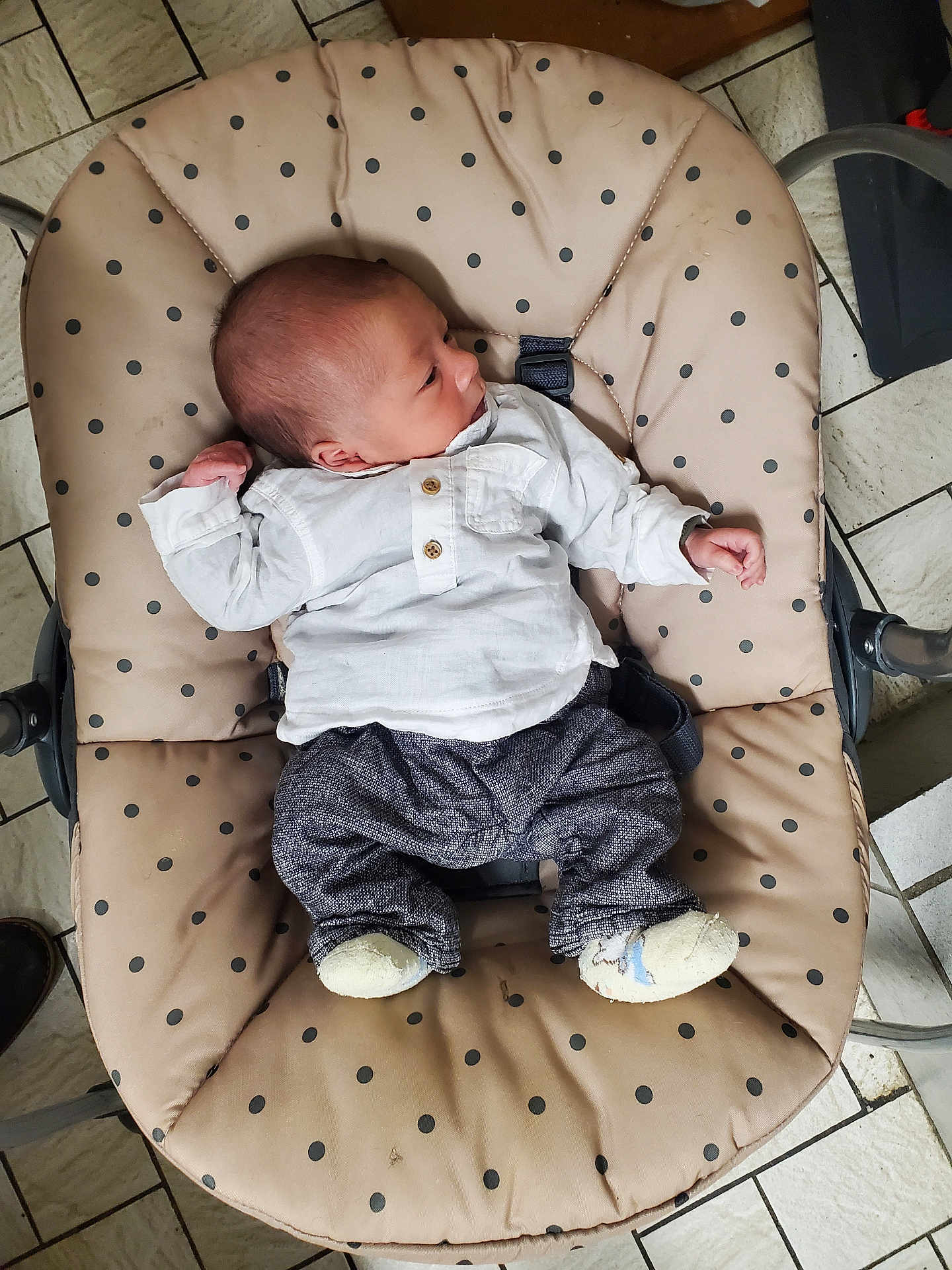 Matheo a rejoint le concours — aidez-le/la à gagner de superbes lots ! baby, infant, baby_seat, polka_dots, clothing, white_shirt, pants, footwear, face, head, arm, hand, floor, tile_floor, indoor, person, newborn, baby_accessory, comfort, resting