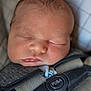 newborn, baby, sleeping, car_seat, straps, face, infant, child, closeup, peaceful, resting, clothing, soft_light, indoors, safety, cute, small_hands, texture, skin, head