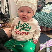 Freya joined the competition — help win amazing prizes! baby, blanket, car_seat, child, clothing, couch, furniture, green_pants, hand, happy, hat, indoor, jolly_and_joyful_shirt, knit_hat, person, portrait, remote_control, smiling, tattoo, white_hat