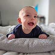 Ayden a rejoint le concours — aidez-le/la à gagner de superbes lots ! baby, infant, smile, tongue_out, towel, bed, blanket, pajamas, hands, face, portrait, indoor, cute, happy, newborn, skin, eyes, mouth, cozy, shallow_depth_of_field