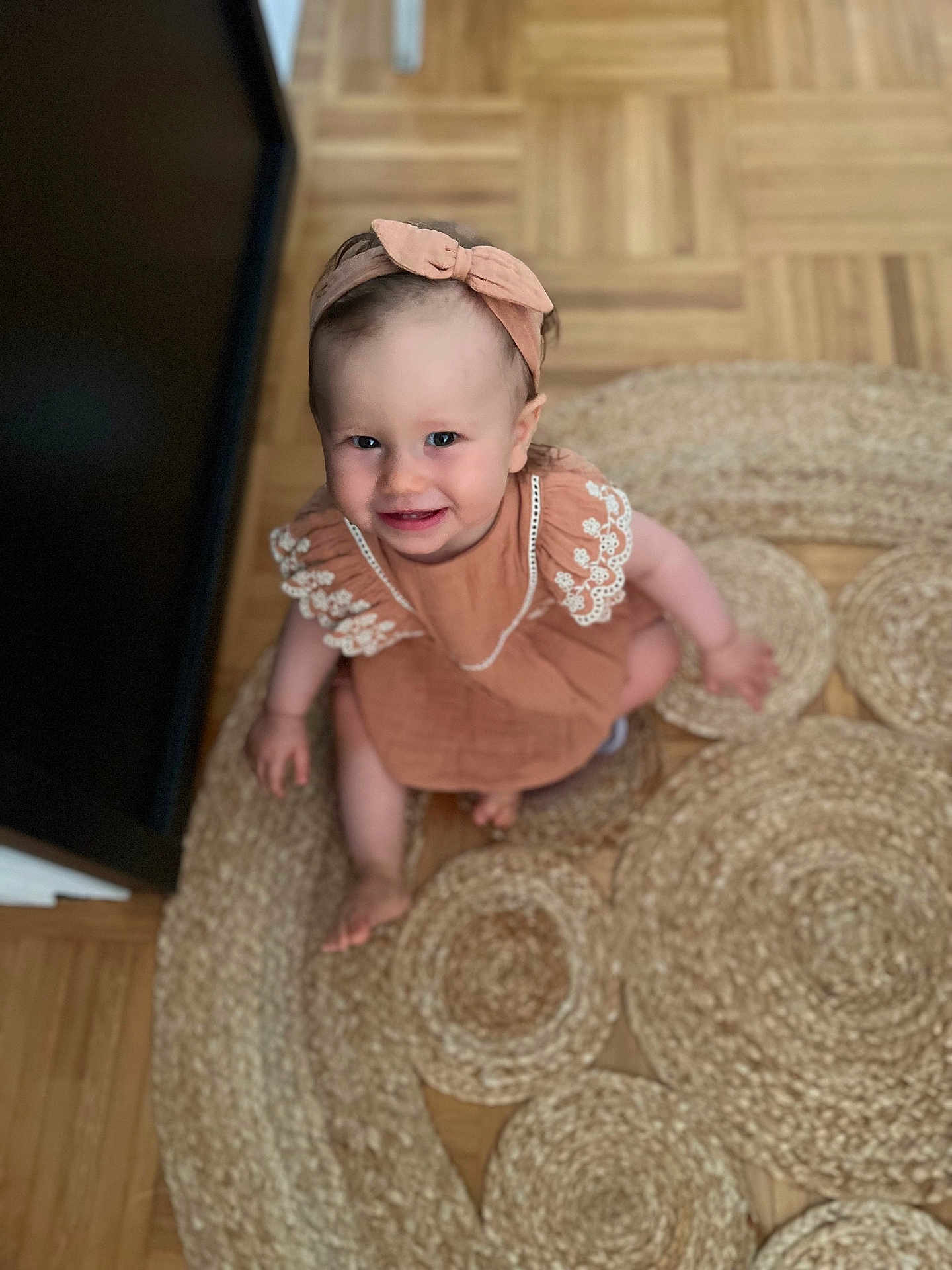 Léna participe au concours pour gagner de l'argent avec cette photo : toddler, child, smiling, headband, dress, indoor, rug, wooden_floor, happy, sitting, baby, person, cute, candid, texture, flooring, home, portrait, looking_up, playful