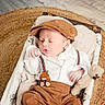 adorable, baby, blanket, cap, clothing, cozy, hat, indoor, infant, newborn, peaceful, plush_toy, portrait, rug, sleeping, small_hand, suspenders, teddy_bear, wicker_basket, wooden_floor