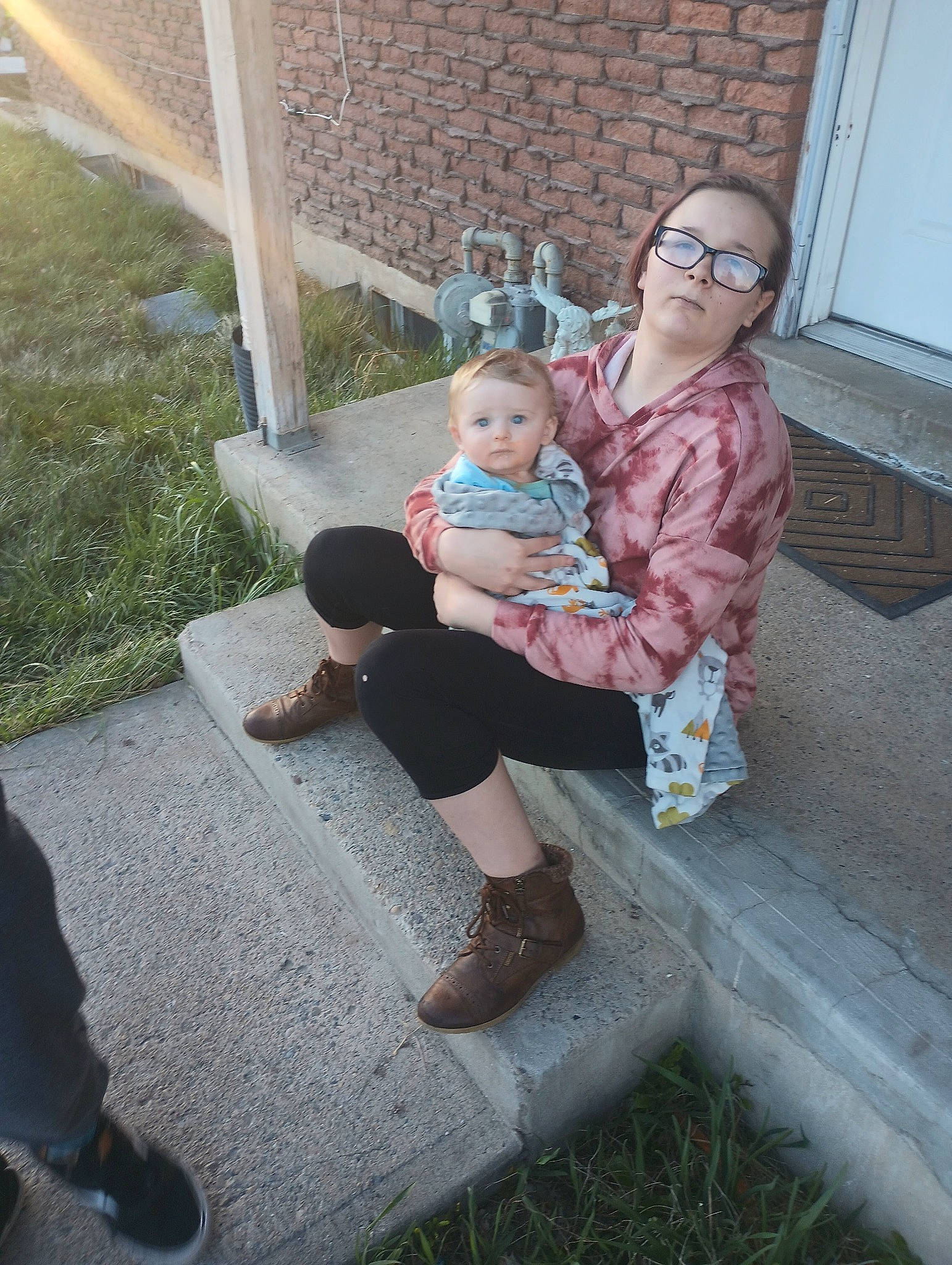 Makayla joined the competition — help win amazing prizes! baby, child, costume, eyewear, foot, fun, grass, human_leg, knee, lap, leg, leisure, person, plant, sandal, shoe, shorts, sitting, thigh, toddler