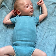 Westyn is registered to the contest to win money with this photo: baby, sleeping, blue_onesie, blanket, infant, peaceful, arms_up, legs_spread, soft_texture, indoor, child, cute, resting, newborn, skin, head, foot, hand, clothing, portrait
