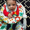 Ryder is registered to the contest to win money with this photo: baby, bib, carpet, child, colorful, cute, face, hands, happy, indoor, infant, patterned_rug, person, playful, red_clothing, sitting, smiling, toys, walker, young