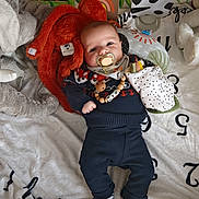 Néo participe au concours pour gagner de l'argent avec cette photo : baby, pacifier, plush_toys, elephant_plush, bear_plush, blanket, numbers, clothing, sweater, pants, necklace, wooden_beads, lying_down, infant, cute, indoor, comfort, child, soft_toys, person