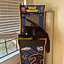 animal, arcade_machine, black_cat, blinds, cat, daylight, feline, floor, furniture, gaming, home, indoor, leisure, mat, pet, relaxed, retro, space_invaders, technology, window