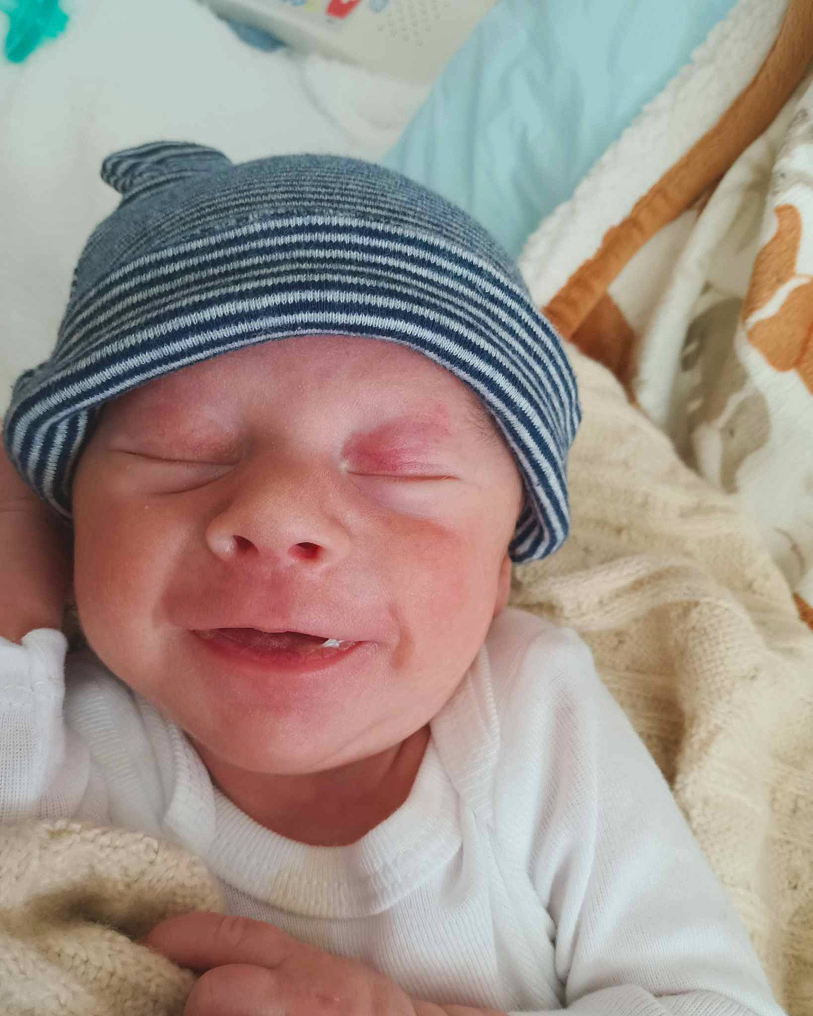 Maddox is registered to the contest to win money with this photo: baby, baby_sleeping, baby_toddler_clothing, cap, cheek, child, comfort, eyebrow, finger, gesture, happy, headgear, headwear, knit_cap, linens, nose, person, skin, smile, textile