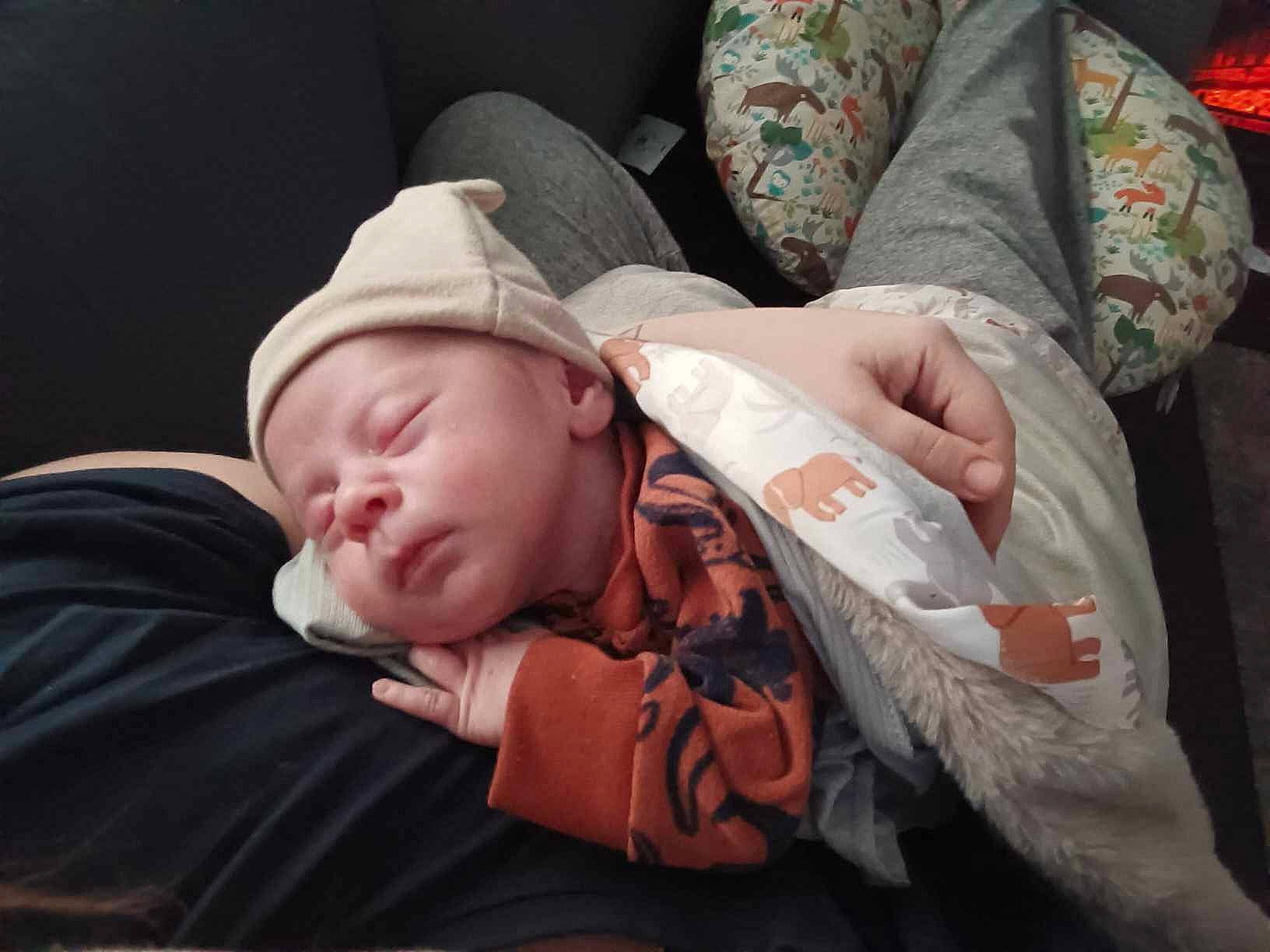 Maddox is registered to the contest to win money with this photo: arm, baby, baby_toddler_clothing, cheek, child, comfort, couch, facial_expression, finger, grass, hand, hat, human_body, mouth, nail, person, sitting, skin, toddler, tree