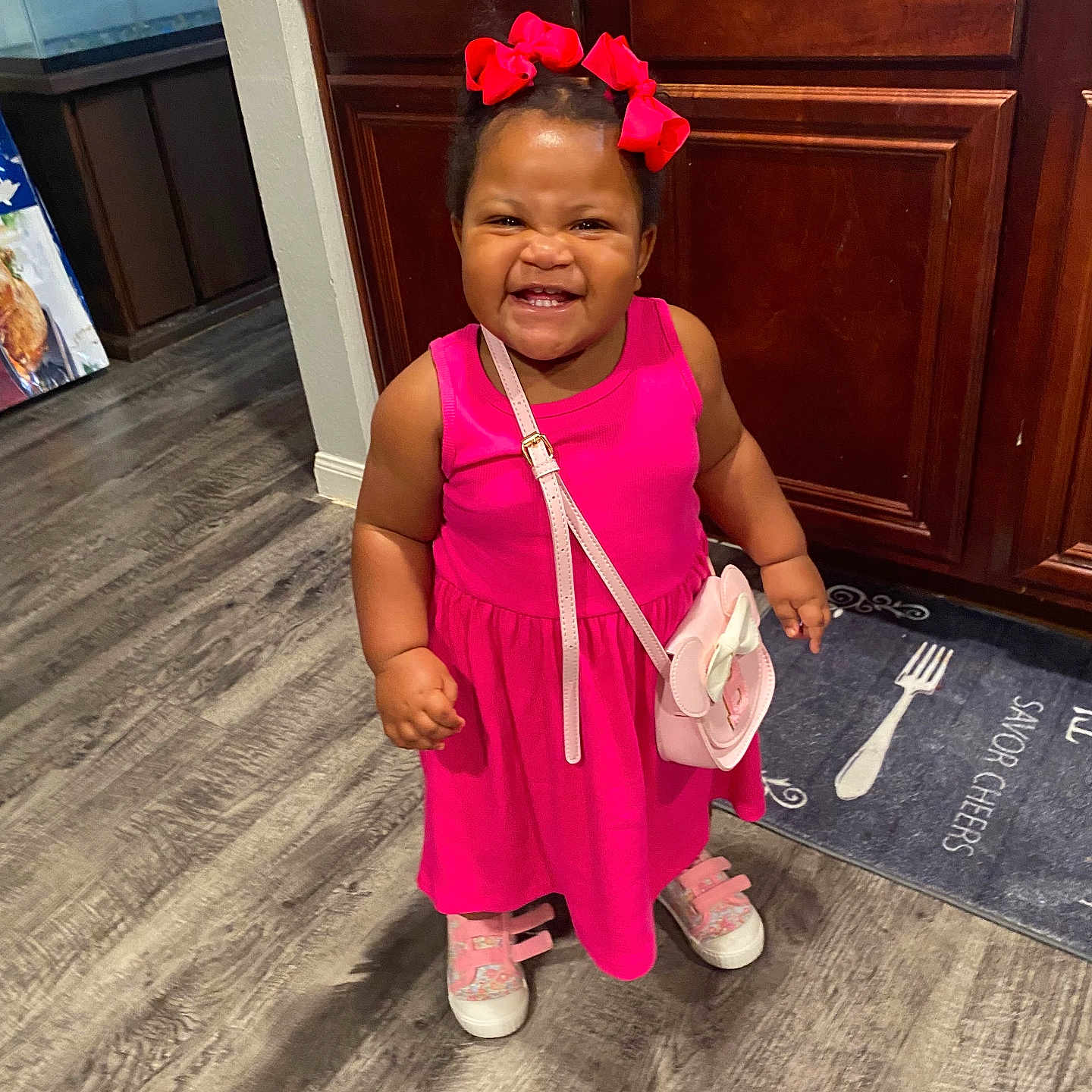 Bella joined the competition — help win amazing prizes! accessory, cabinet, child, cute, expression, fashion, floor, hair_bows, happy, indoor, kitchen, person, pink_dress, purse, shoes, smiling, standing, toddler, wood_floor, young_child