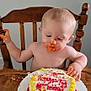 Liam joined the competition — help win amazing prizes! baby, birthday_cake, cake, celebration, child, face, food, frosting, hands, happy, high_chair, indoor, messy, person, plate, red_frosting, smudged, table, wooden_chair, yellow_frosting