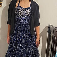 Reneelee is registered to the contest to win money with this photo: child, girl, smiling, dress, sparkly, navy_blue, indoor, footwear, sandals, shrug, standing, crib, floor, wall, person, happy, young, blond_hair, casual, home