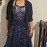 child, girl, smiling, dress, sparkly, navy_blue, indoor, footwear, sandals, shrug, standing, crib, floor, wall, person, happy, young, blond_hair, casual, home