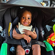 Kaëline participe au concours pour gagner de l'argent avec cette photo : baby, bracelet, bright, car_accessory, car_interior, car_seat, casual_clothing, child, child_safety, curly_hair, cute, happy, indoor, infant, pacifier, playful, safety_harness, seat_belt, smiling, toy