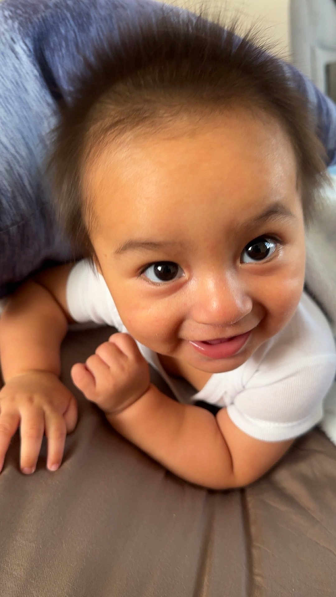 Thiago joined the competition — help win amazing prizes! baby, infant, child, crawling, smiling, cute, face, eyes, cheeks, skin, arm, hand, white_clothing, pillow, soft_surface, indoors, portrait, closeup, happy, curious
