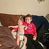 Roman is registered to the contest to win money with this photo: baby, child, siblings, infant, toddler, smiling, sitting, couch, sofa, blanket, pillows, indoor, portrait, family, spiderman, red_sweater, diaper, backpack, fan, cozy