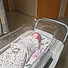 Chelsea is registered to the contest to win money with this photo: newborn, baby, hospital, bassinet, blanket, swaddled, infant, floor, door, medical, room, hospital_room, plastic_bassinet, peaceful, sleeping, wrapped, footprint_pattern, curtain, hospital_equipment, indoor